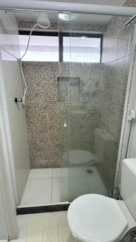 a bathroom with a glass shower with a toilet at FLAT MAR E SOL 106 A 50m PRAIA in Porto De Galinhas