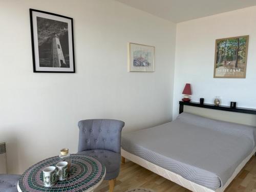 une chambre avec un lit, une table et une chaise dans l'établissement Studio bord de mer, balcon, animaux bienvenus, parking - Notre-Dame-de-Monts - FR-1-540-315, à Notre-Dame-de-Monts