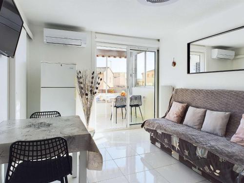 un salon avec un canapé et une table dans l'établissement Appartement climatisé 2 pièces + cabine avec parking au cœur de Marseillan-Plage - FR-1-326-847, à Marseillan
