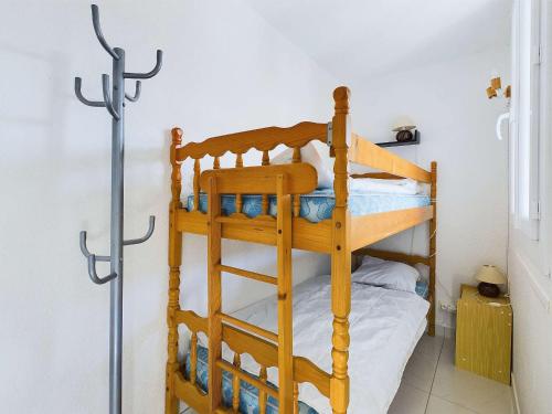 Ce lit superposé se trouve dans un dortoir avec une échelle. dans l'établissement Appartement climatisé 2 pièces + cabine avec parking au cœur de Marseillan-Plage - FR-1-326-847, à Marseillan