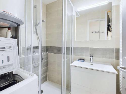 une salle de bain avec une machine à laver et un lavabo dans l'établissement Appartement climatisé 2 pièces + cabine avec parking au cœur de Marseillan-Plage - FR-1-326-847, à Marseillan