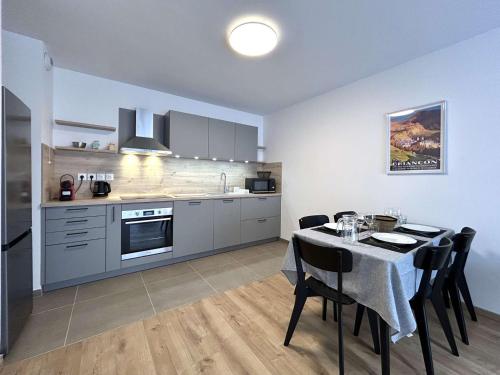 une cuisine avec une table avec des chaises et une salle à manger dans l'établissement Appartement 3 pièces, 2 chambres, balcon, vue Briançon, WiFi gratuit - FR-1-330C-150, à Briançon