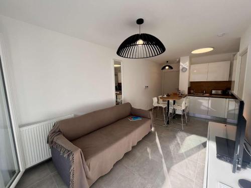 un salon avec un canapé et une cuisine dans l'établissement Appartement T2 bis 40m² avec Terrasse et Parking à Cavalaire-sur-Mer - FR-1-226B-232, à Cavalaire-sur-Mer