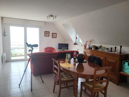 a living room with a table and a couch at Les Balcons de la Mer in Erquy