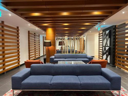 a living room with blue couches and orange chairs at The Signature at CityPlace in Toronto