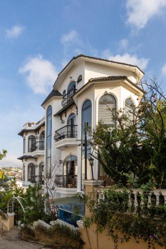a large white house with a lot of windows at Adalia Villa With ValeyView - O'TEL in Da Lat