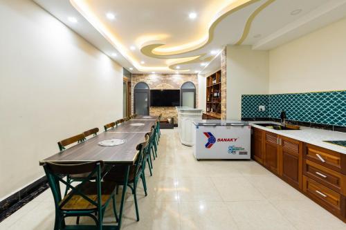 a large kitchen with a long table and chairs at Adalia Villa With ValeyView - O'TEL in Da Lat