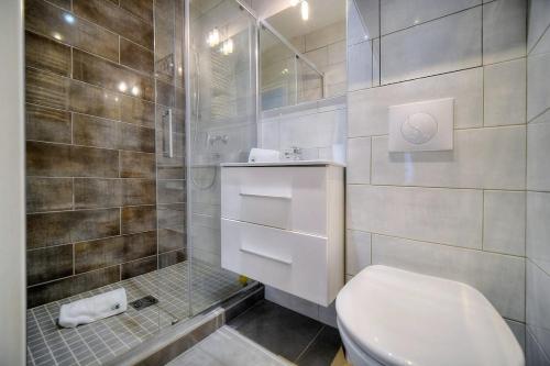 une salle de bain blanche avec toilettes et douche dans l'établissement Appartement Juliette - 500m FROM THE BEACH, à Cannes