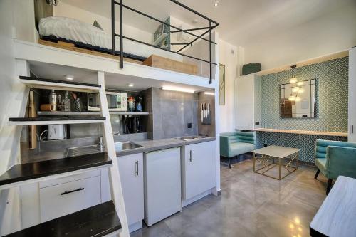 - une cuisine avec des placards blancs, un évier et une table dans l'établissement Studio Colette mezzanine - 500m FROM THE BEACH, à Cannes