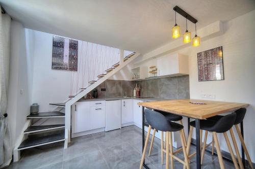 une cuisine avec une table en bois et un escalier dans l'établissement App. Suzette Duplex - 500m FROM THE BEACH, à Cannes