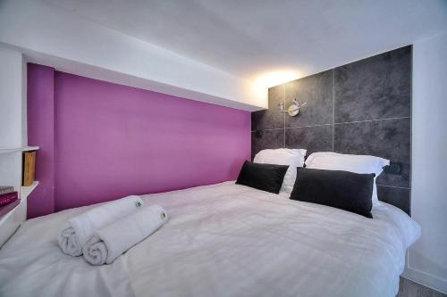 - une chambre avec un grand lit blanc et un mur violet dans l'établissement Studio Paulette mezzanine - 500m FROM THE BEACH, à Cannes