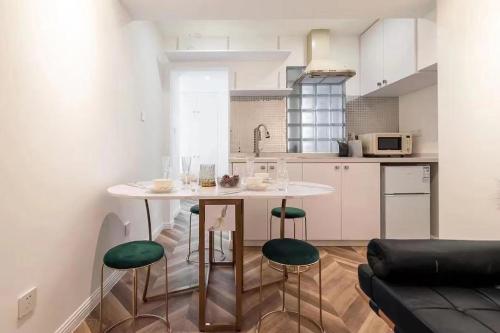 a kitchen with a table and some green chairs at Tonight Homestay West Nanjing Road Branch Shanghai in Shanghai