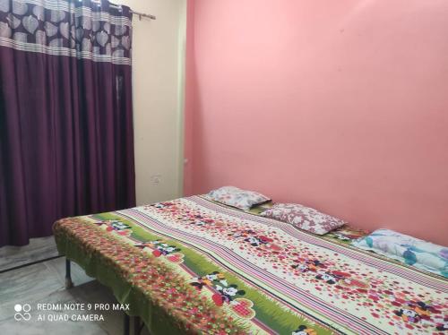 a bed with a blanket on it in a bedroom at Manshi Niwas in Prayagraj