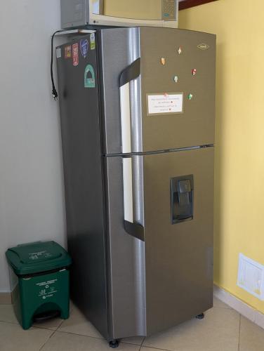 a stainless steel refrigerator in a room with a trash can at Edificio Macondo en el Rodadero con vista al mar, NO se paga manilla in Rodadero