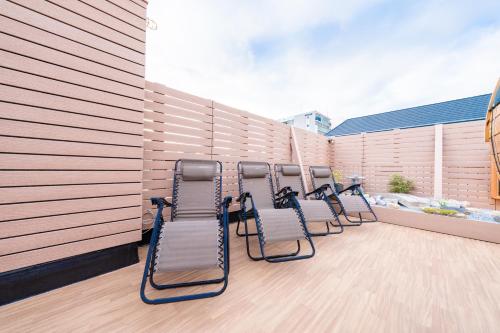 a row of chairs sitting on a balcony at 安 Ann サウナで整う貸切の宿 USJ 万博会場近く 無料駐車場 寝室6 バスルーム4点 in Osaka