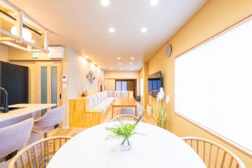 a kitchen and dining room with a table and chairs at 安 Ann サウナで整う貸切の宿 USJ 万博会場近く 無料駐車場 寝室6 バスルーム4点 in Osaka