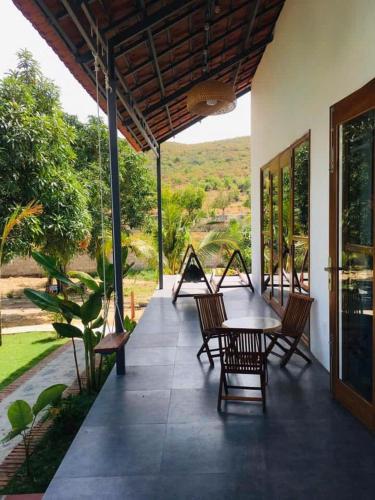 a patio with a table and chairs on a house at My Anh Garden in Ấp Thiẹn Ái