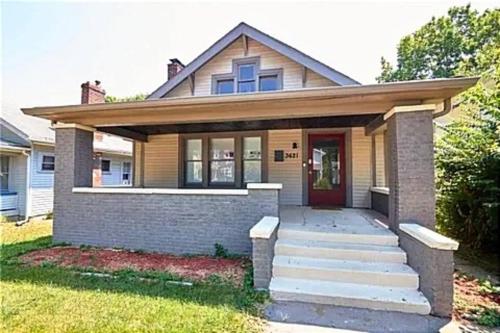 a house with a red door and a porch at Private Room in an Elegant Home- Convenient to Downtown Indianapolis in Indianapolis