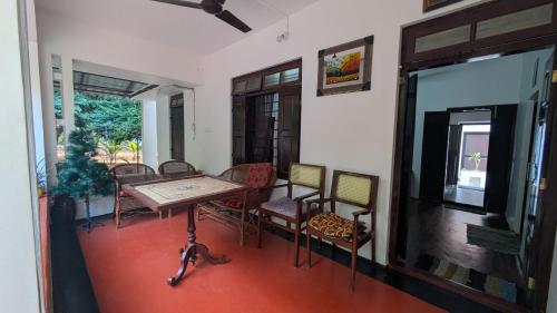 a room with a table and chairs and a television at Aalmaram By Kizhakeyil Private Pool Heritage Villa in Trivandrum