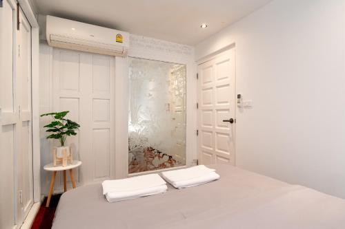 Un dormitorio blanco con una cama y una ventana. en Designer house Chao Phraya River - OH Homes 12, en Bangkok
