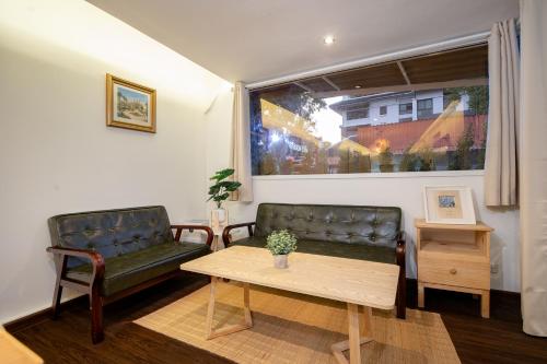 a living room with two leather chairs and a table at Designer house Chao Phraya River - OH Homes 12 in Bangkok