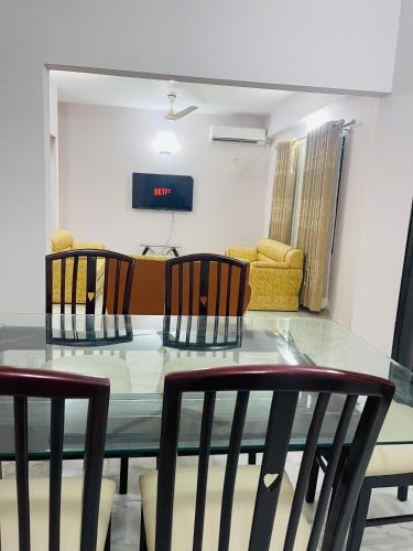 a dining room with a glass table and chairs at Uttara Luxury Apartment Near Airport & Metro in Dhaka