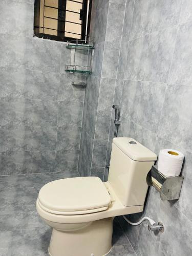 a bathroom with a white toilet in a room at Uttara Luxury Apartment Near Airport & Metro in Dhaka