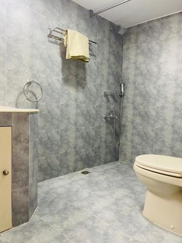 a bathroom with a toilet and a shower at Uttara Luxury Apartment Near Airport & Metro in Dhaka