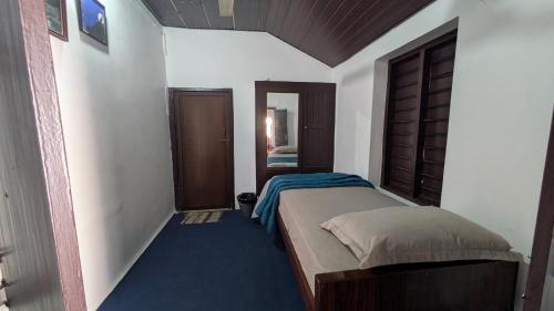 a small bedroom with a bed and a mirror at Aalmaram By Kizhakeyil Private Pool Heritage Villa in Trivandrum