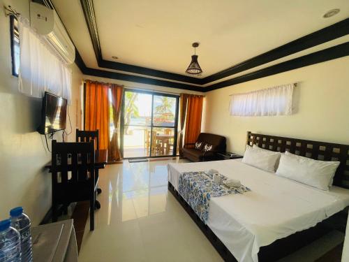 a bedroom with a large white bed and a window at Bolo Hills Beach Club And Residence in Alaminos