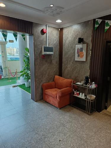 a living room with an orange couch in a room at أجنحة المدينة للشقق المفروشة in Al Madinah