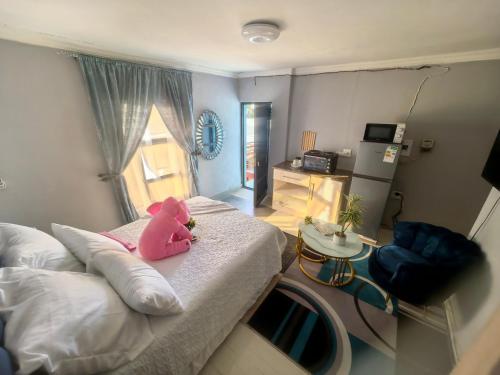 a pink teddy bear sitting on a bed in a room at samama guesthouse in Groblersdal