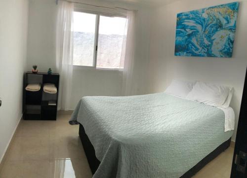 un dormitorio con una cama y una ventana en Casa Los Arcos, en Oaxtepec