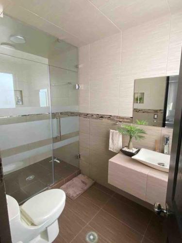 a bathroom with a toilet and a sink and a mirror at Casa Los Arcos in Oaxtepec