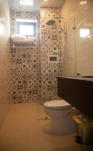 a bathroom with a toilet and a glass shower at BaKa Hotel - Khách sạn Tuy Hòa in Liên Trì (3)