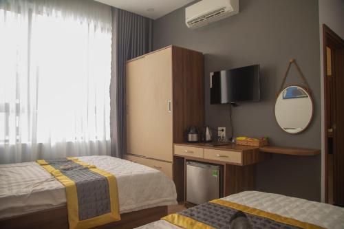 a hotel room with two beds and a mirror at BaKa Hotel - Khách sạn Tuy Hòa in Liên Trì (3)