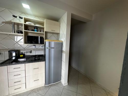 a kitchen with a stainless steel refrigerator and cabinets at LOFT no Centro de Joaçaba in Joaçaba