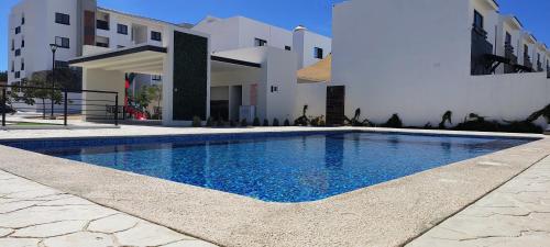 a swimming pool in front of a building at Condo located 8 min from DT & 15 min from Airport in San José del Cabo