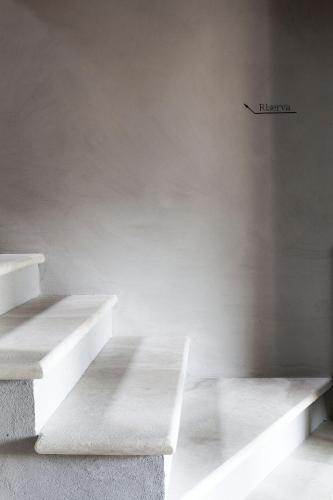 a room with white stairs and a sign on the wall at Salcheto WineHouse in Montepulciano