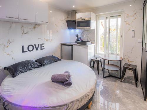- une chambre dotée d'un lit avec un signe d'amour sur le mur dans l'établissement Le Topaze - Spa & Jacuzzi, à Manosque