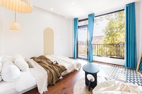 a bedroom with a bed and a large window at Be Youth Villa Đà Lạt - O'TEL in Da Lat