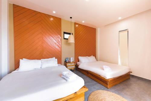 a bedroom with two beds and a chair at Be Youth Villa Đà Lạt - O'TEL in Da Lat
