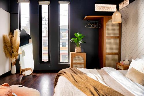 a bedroom with a large bed and windows at Be Youth Villa Đà Lạt - O'TEL in Da Lat