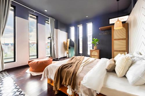 a bedroom with blue walls and a large bed with pillows at Be Youth Villa Đà Lạt - O'TEL in Da Lat