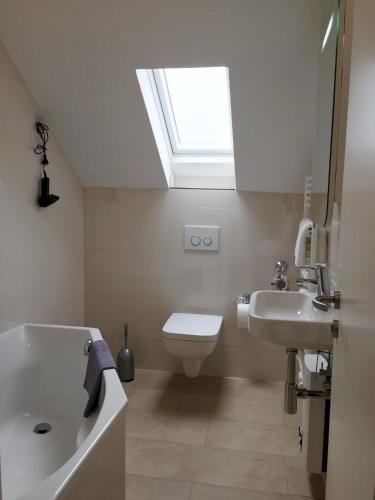 a bathroom with a sink and a toilet and a skylight at Ferienwohnung Kreuder in Bergisch Gladbach