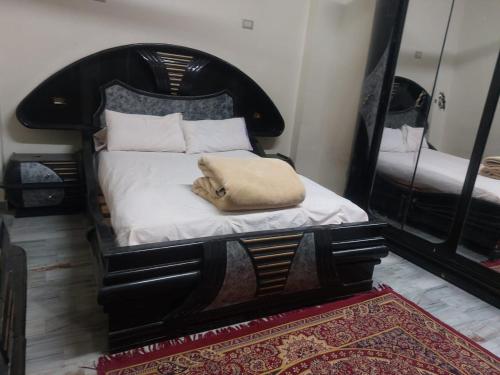 a bedroom with a black bed with a pillow on it at Horus apartment in Al Bayāḑīyah