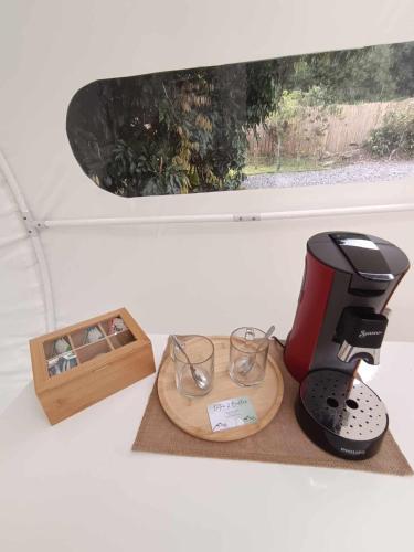 a coffee maker and glasses on a cutting board at Entre 2 bulles in Entre-Deux