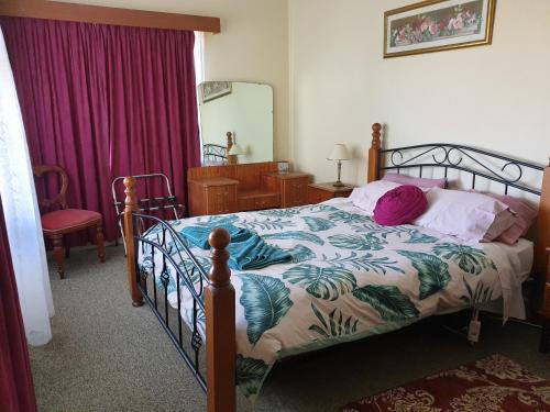 Un dormitorio con una cama con un edredón verde y blanco. en Kirazz Holiday Homes, en Kingscote