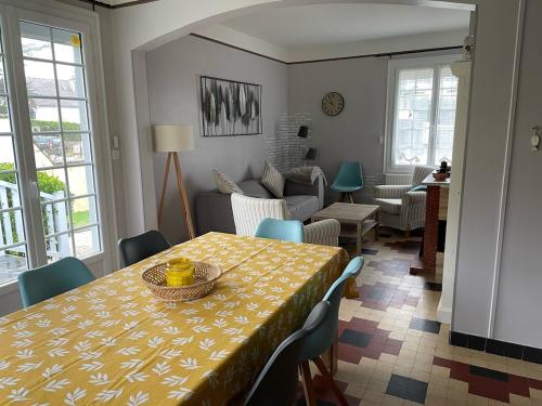 une salle à manger avec une table et un salon dans l'établissement Les Ilous proche mer, à Hauteville-sur-Mer