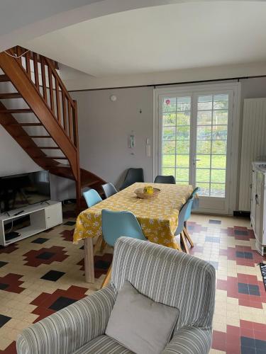 un salon avec une table et des chaises de salle à manger dans l'établissement Les Ilous proche mer, à Hauteville-sur-Mer
